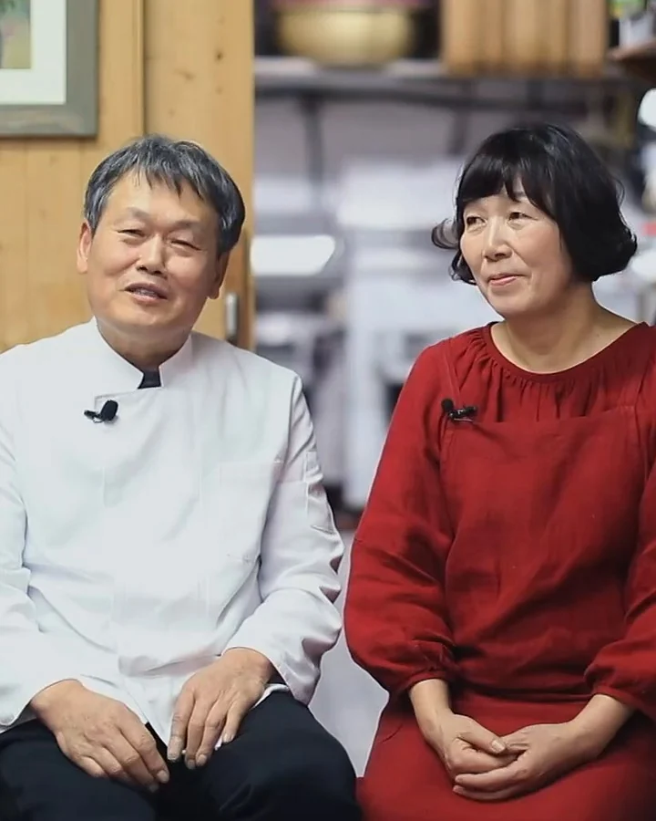 가게 안에 나란히 앉아 웃는 사장님 부부